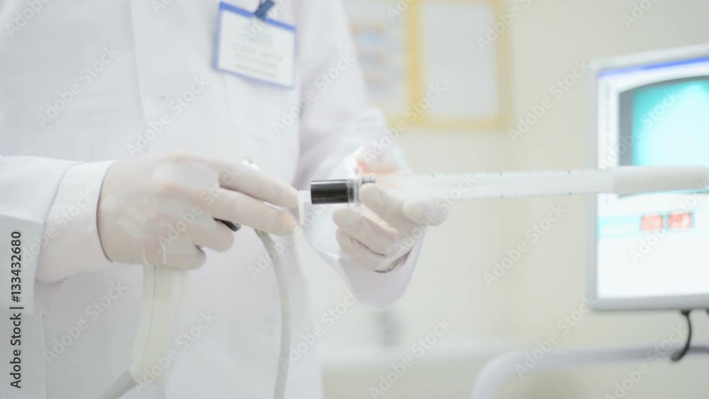 proctologist holding anoscope (proctoscope) proctologist holding anoscope (proctoscope)