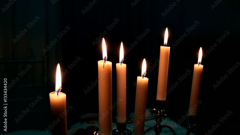 Element of the decor - burning candles in candleholders. Element of the decor - burning candles in candleholders.