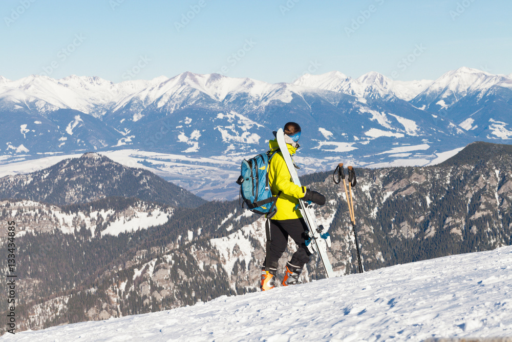 Female skier taking a look at landscape from the top of a mountain Female skier taking a look at landscape from the top of a mountain