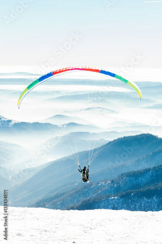 Paraglider launched into air from a mountain peak