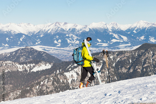 Female skier taking a look at landscape from the top of a mountain