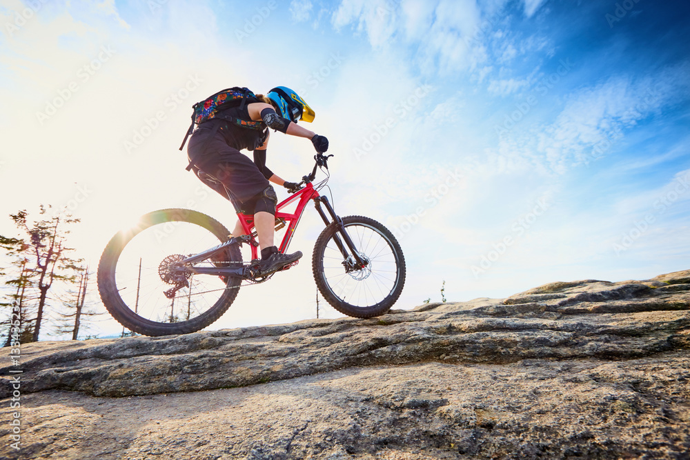 Young woman biking, riding uphill on MTB fullsuspension bike Young woman biking, riding uphill on MTB fullsuspension bike