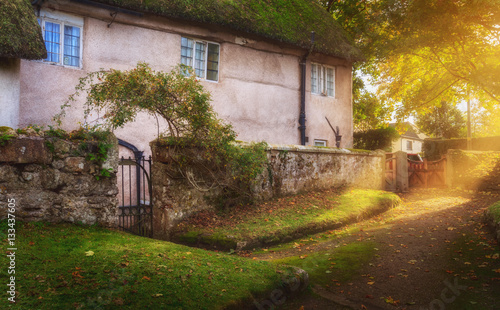 Courtyard at the old two-storey house. Evening. Autumn. A ray of sunshine breaking through leaves. Chagford. Dartmoor. Devon. UK