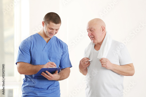 Physiotherapist with elderly patient in clinic