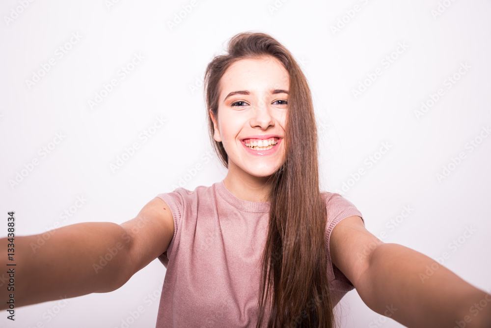 Young happy smile girl take selfie on white background Young happy smile girl take selfie on white background