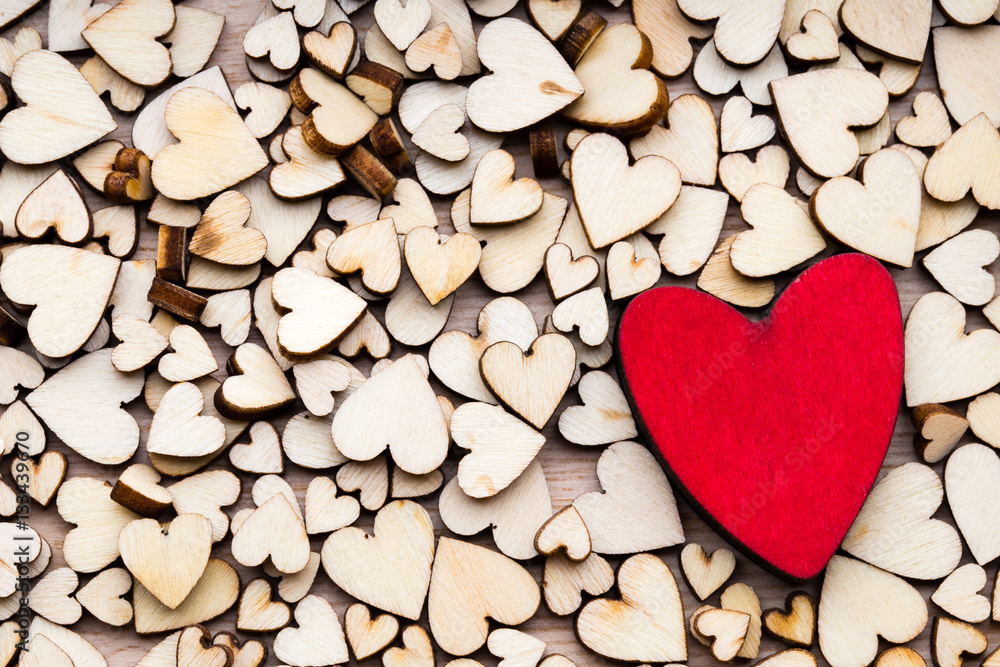 Wooden hearts, one red heart on the heart background.
