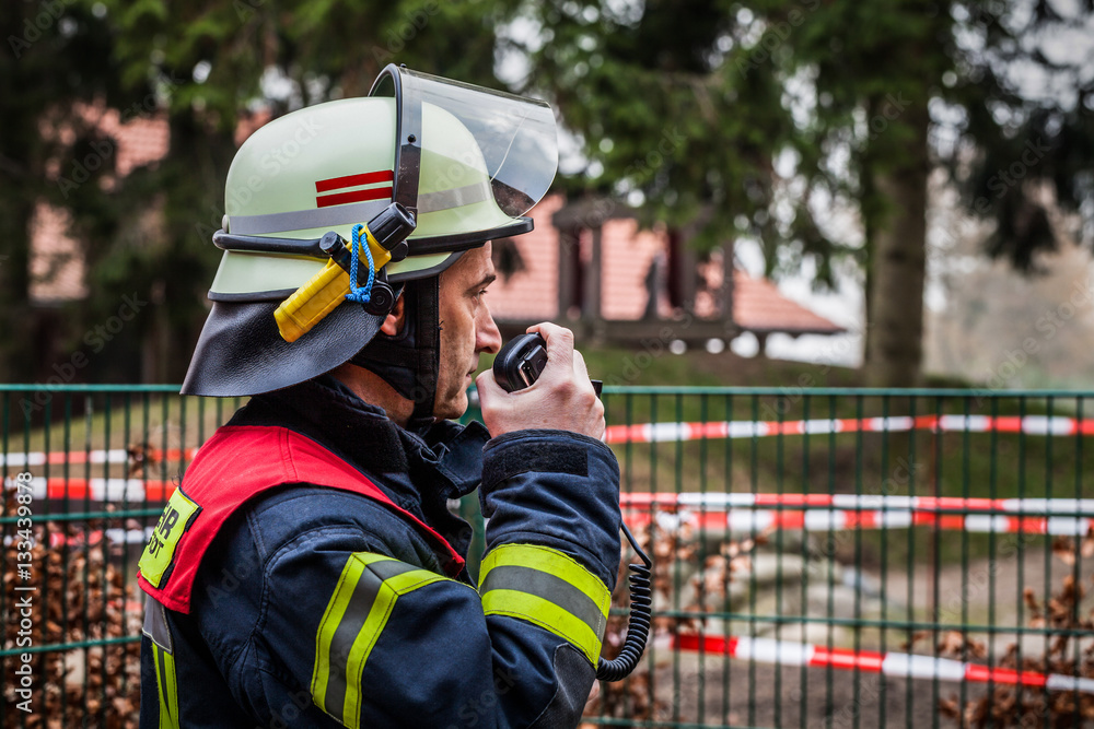 Naklejka premium HDR - Einsatzleiter der Feuerwehr im Einsatz mit Funkgerät Walkie Talkie