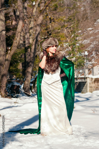 Beautiful blonde woman in winter clothes in the park