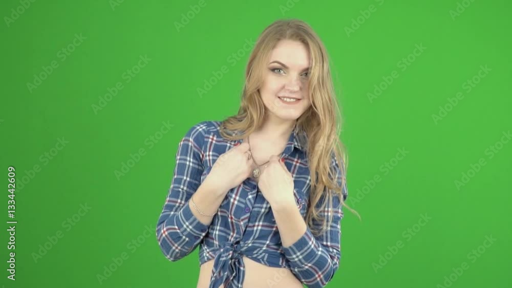 Young girl in shirt tied in a knot her hands pressed to her breast flirts,biting his lip Young girl in shirt tied in a knot her hands pressed to her breast flirts,biting his lip
