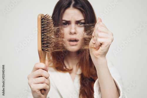 Fotografie girl with a comb in his hand on a white background distressed hair