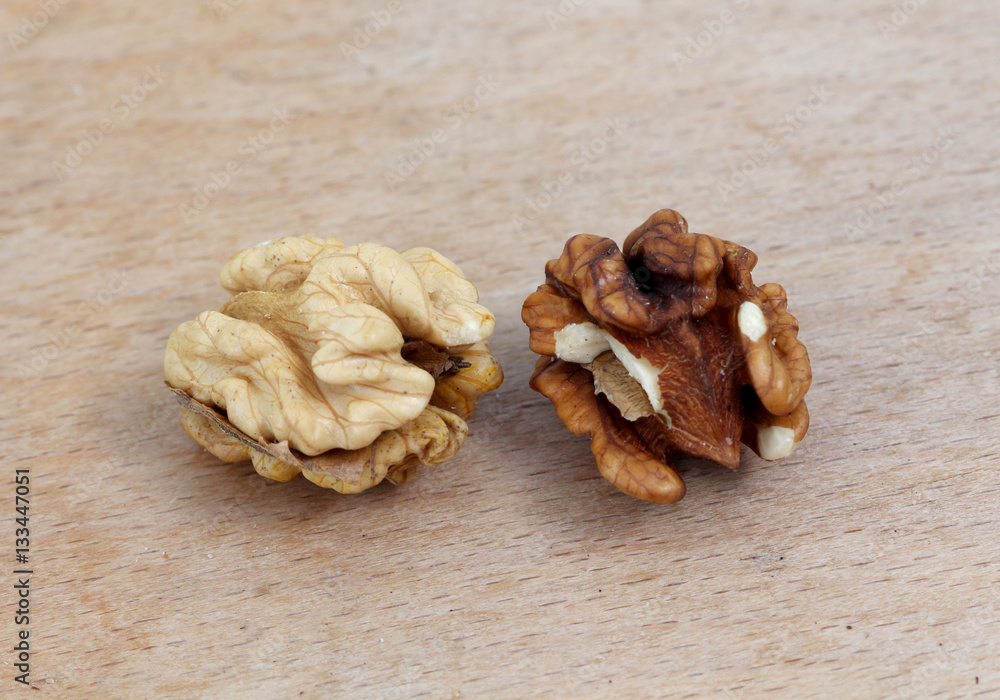 two organic walnuts on a wood background two organic walnuts on a wood background