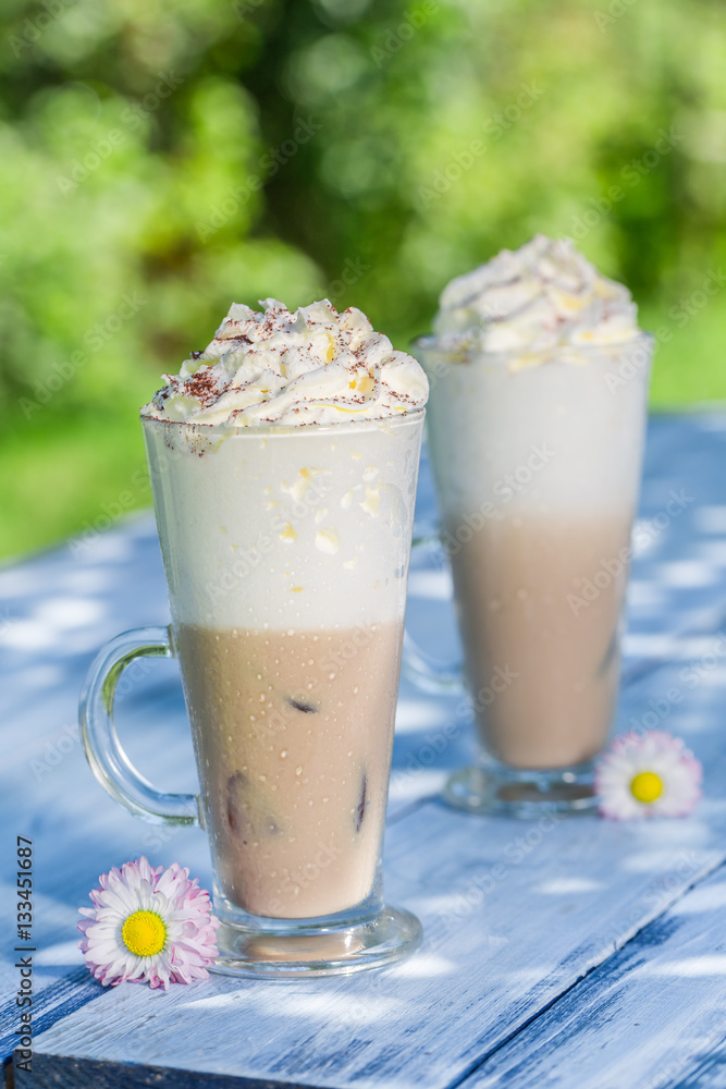 Cold coffee with whipped cream in sunny garden Cold coffee with whipped cream in sunny garden