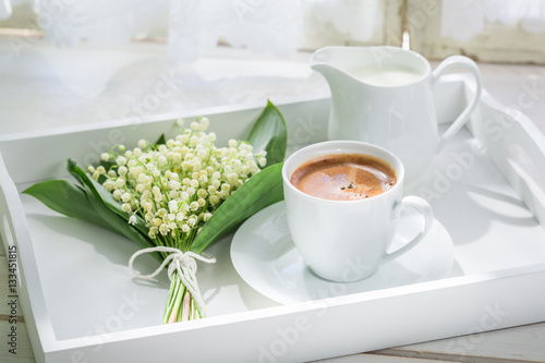 Delicious espresso with flowers on white table