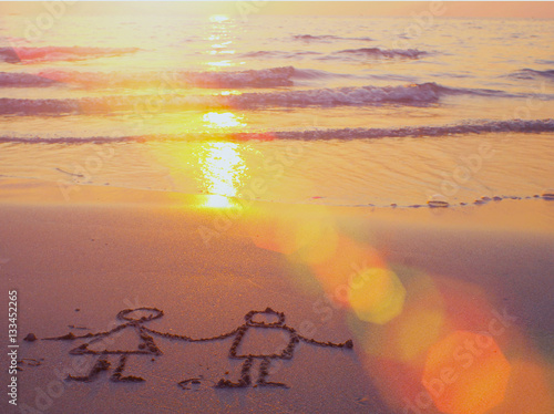 Sunset on the beach and romantic drawing in the sand.