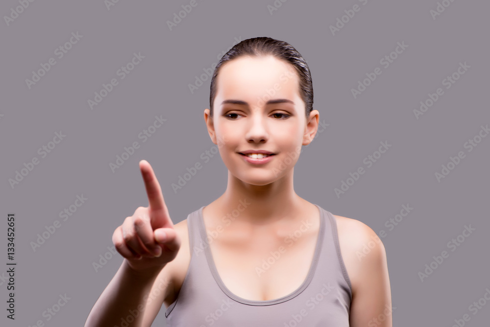 Young sports girl pressing virtual button Young sports girl pressing virtual button