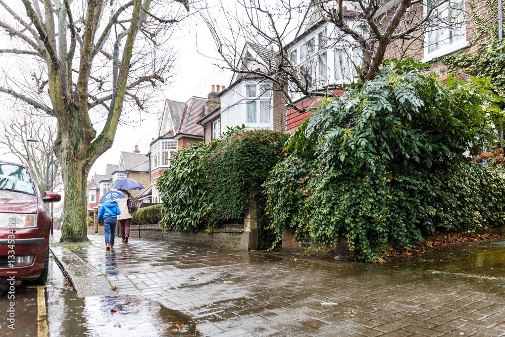 Obraz premium People walk in winter rain in London subrub