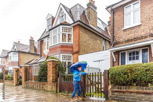 Photography People walk in winter rain in London subrub