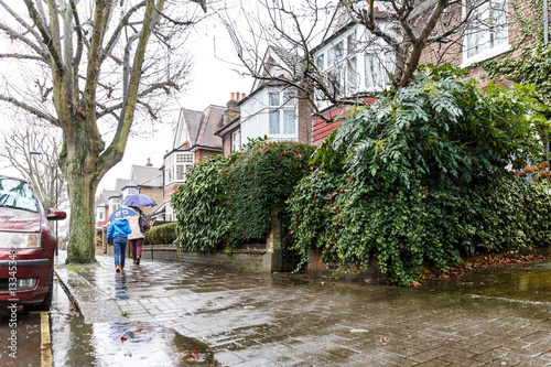 People walk in winter rain in London subrub photo