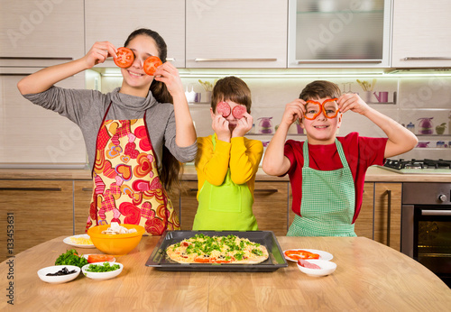 Three funny kids making the pizza