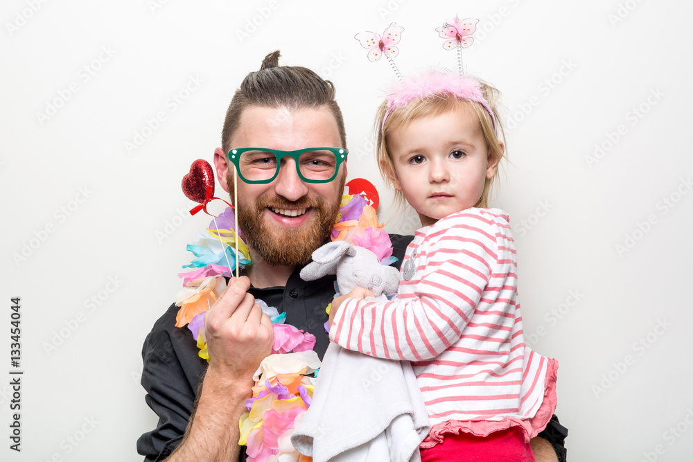 young man and baby happy smile posing on white background with party accessory props photo booth