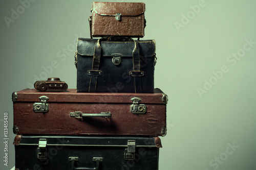 Background stack of old shabby suitcases and camera © kanzefar