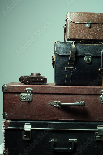 Background stack of old shabby suitcases and camera