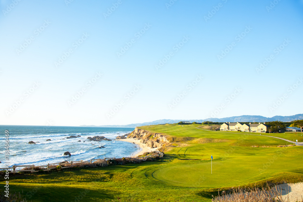 Golf course putting green and cliffs by the pacific ocean bay. Halfmoon Bay California. Villas and houses. Golf course putting green and cliffs by the pacific ocean bay. Halfmoon Bay California. Villas and houses.