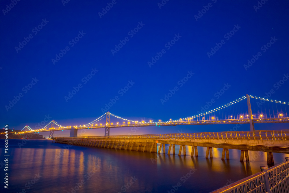 Fototapeta premium San Francisco Bay Bridge and Pier 14 at night with street lights