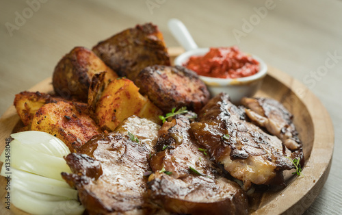 Grill special - chicken fillet cuts of smoked chicken drumstick meat, served with tasty baked potatoes and onions