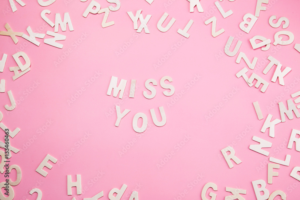 Sorting letters MISS YOU on pink.