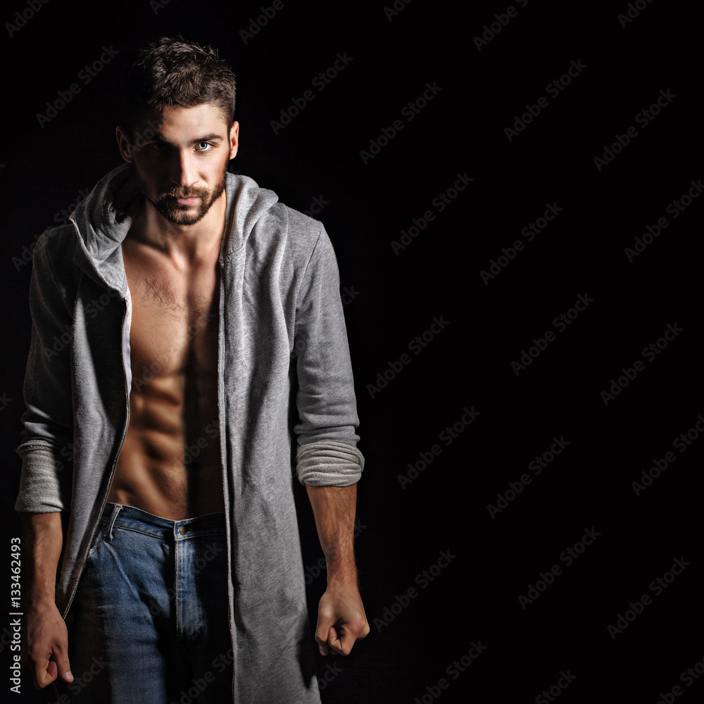 Man in sweatshirt and jeans. Piercing eyes. Husky eyes. Dramatic portrait in sporty style. Men's strength. Man in sweatshirt and jeans. Piercing eyes. Husky eyes. Dramatic portrait in sporty style. Men's strength.