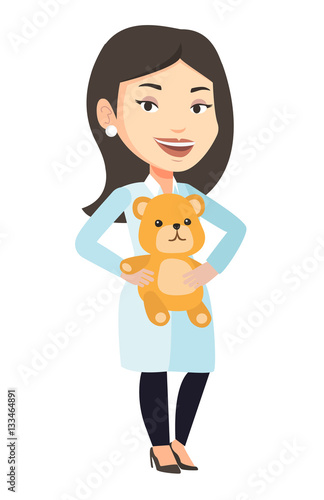 Pediatrician doctor holding teddy bear.