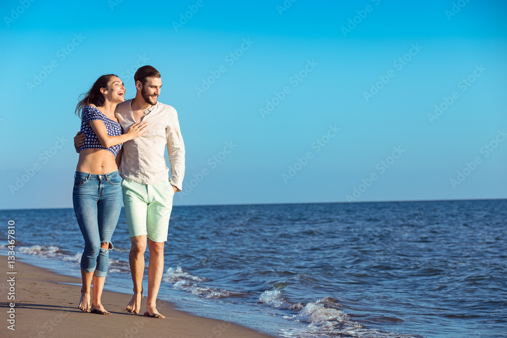 Couple walking on beach. Young happy interracial couple walking on beach. Couple walking on beach. Young happy interracial couple walking on beach.