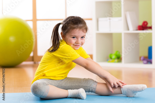Child doing fitness exercis...