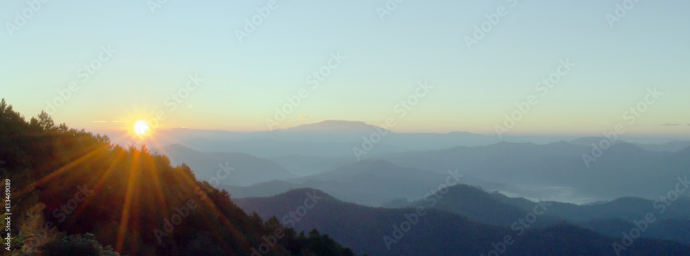 Panoramic landscape in spring with sunlight at the top of mounta