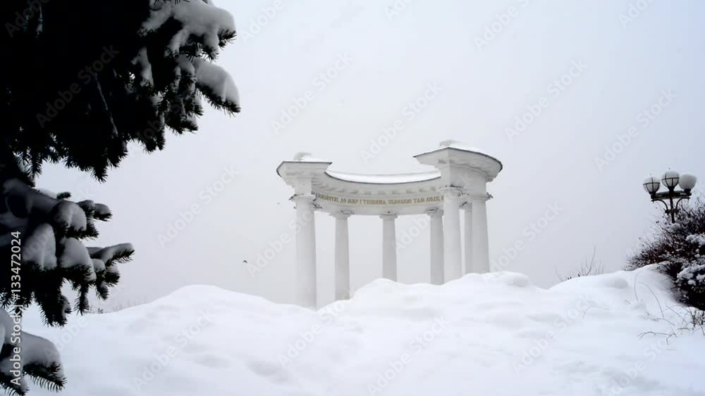Winter. It is snowing. View of the monument of Poltava - White alcove. Ukraine.
