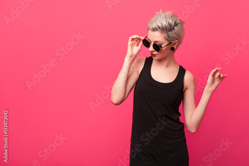 Stylish blond young woman in a retro round sunglasses