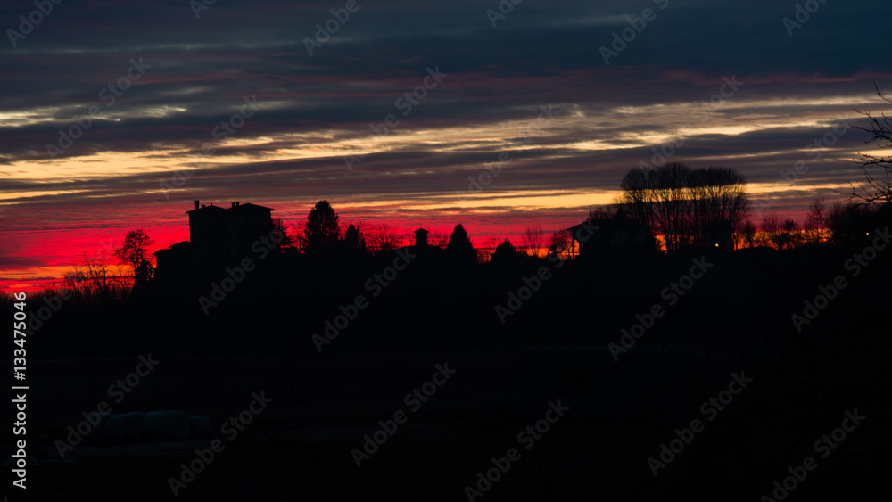 Obraz premium Tramonto infuocato sulle colline 