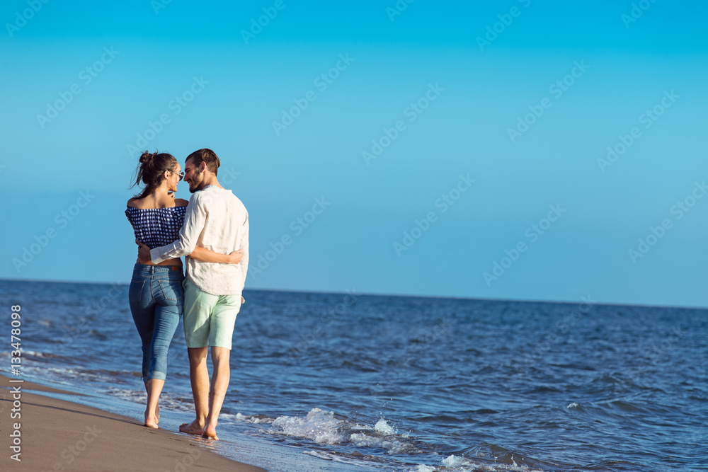 Couple walking on beach. Young happy interracial couple walking on beach. Couple walking on beach. Young happy interracial couple walking on beach.