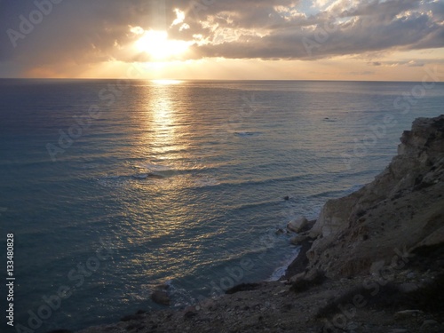 beautiful romantic sunset at a rocky seashore © luciezr