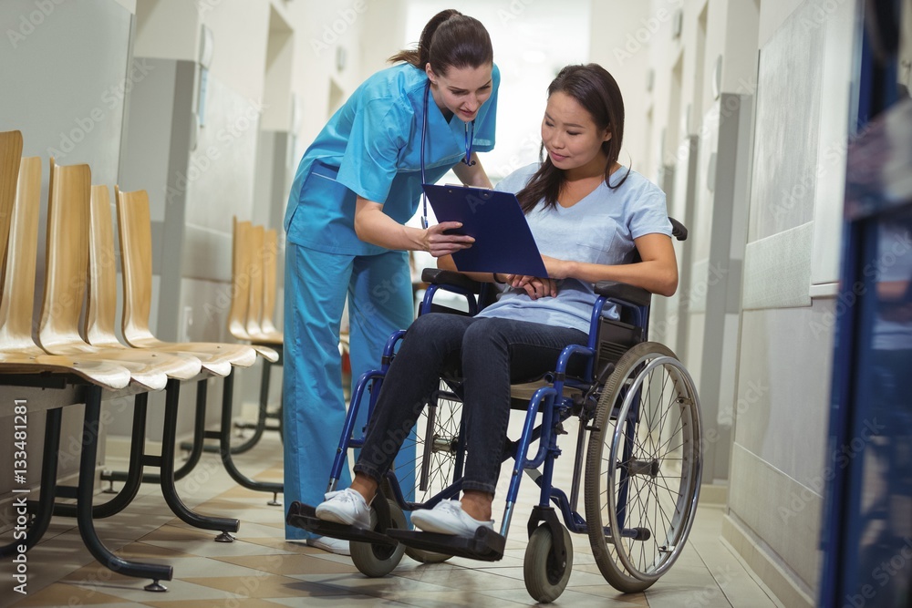 Female nurse assisting patient over clipboard Female nurse assisting patient over clipboard