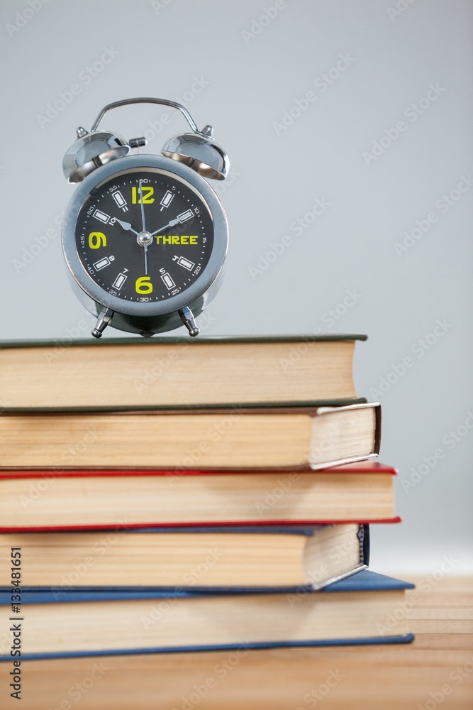 Alarm clock and stack of books Alarm clock and stack of books
