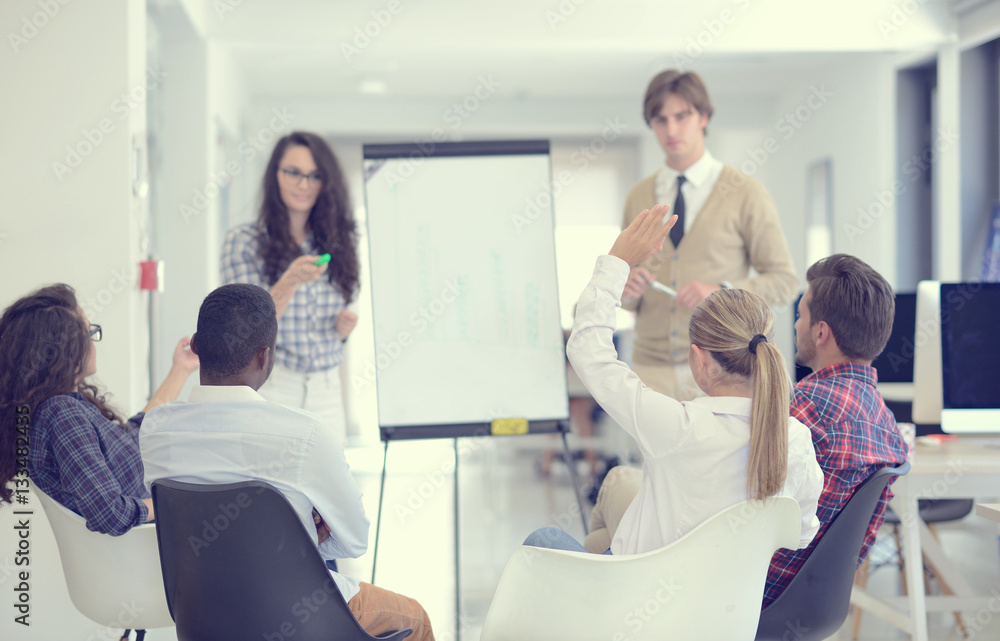 Businessman giving a presentation to his colleagues at work standing in front of a flipchart Businessman giving a presentation to his colleagues at work standing in front of a flipchart