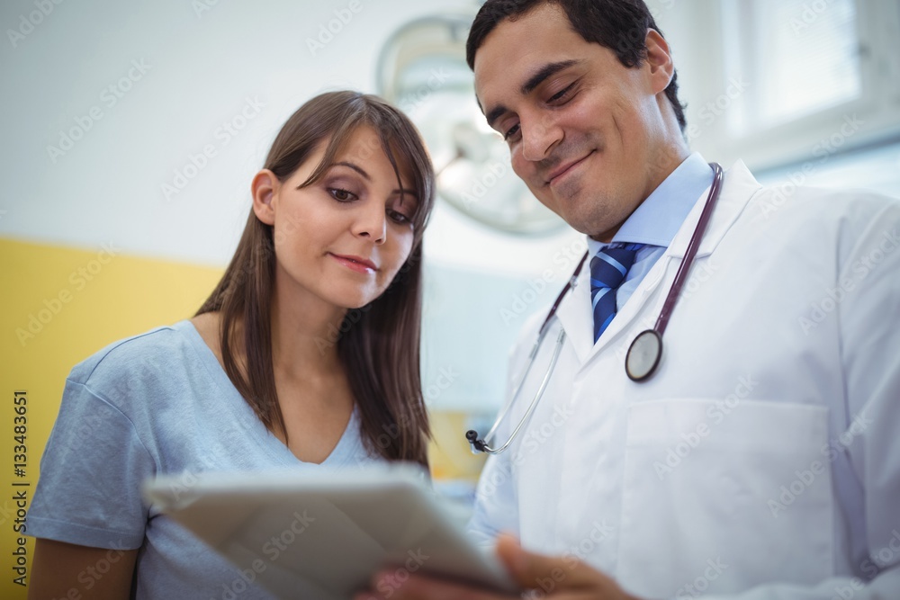 Doctor assisting female patient on digital tablet Doctor assisting female patient on digital tablet