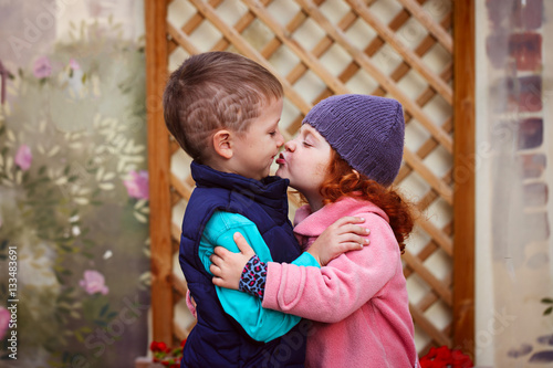 Little girl kissed for the first time adorable little boy. Love and romantic concept