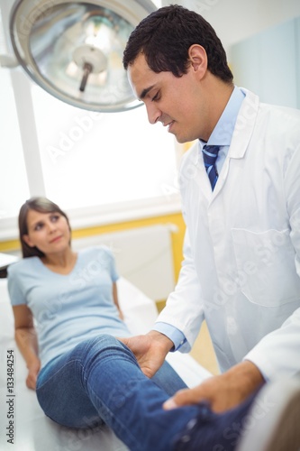 Doctor examining a female patients leg