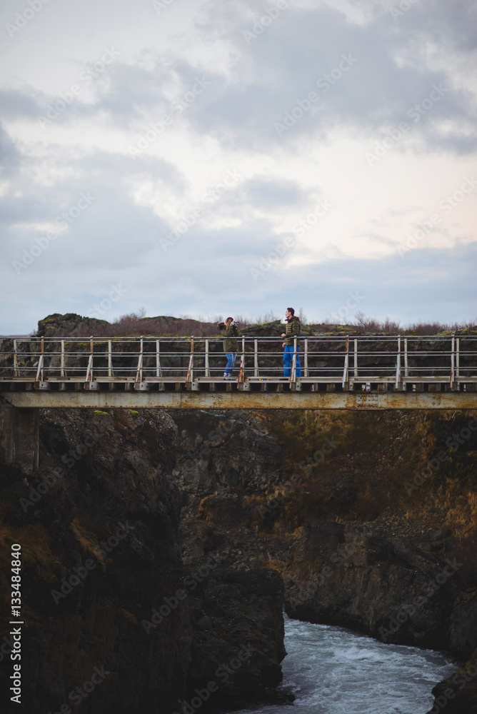 Woman Making Photo of Man on Bridge Woman Making Photo of Man on Bridge