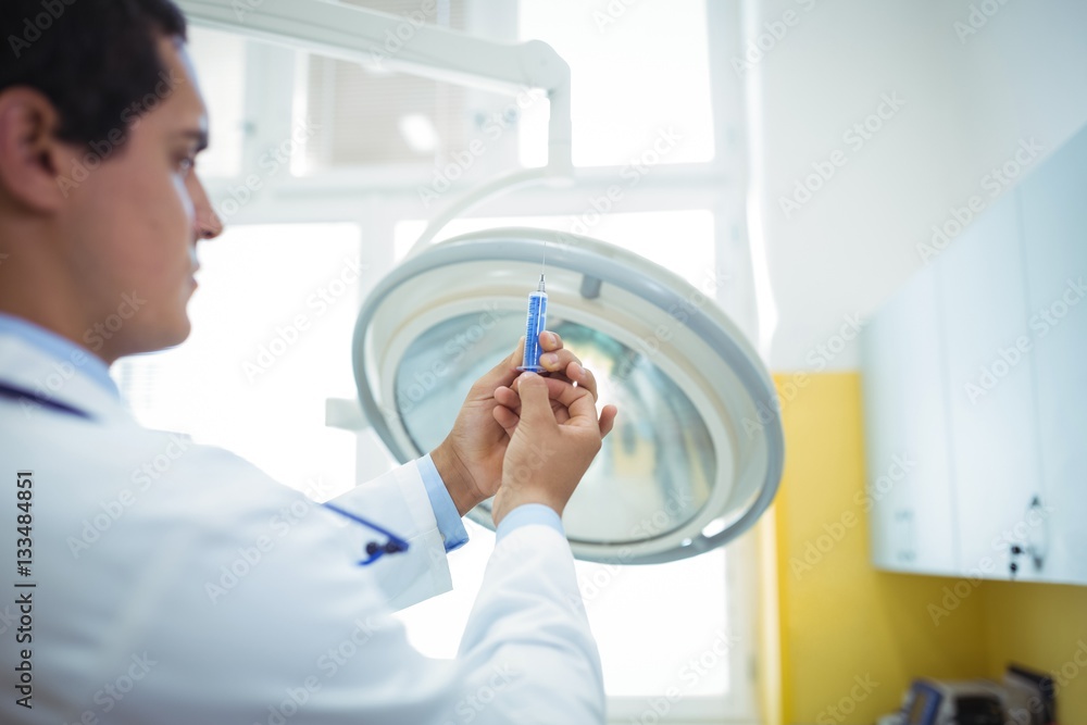 Doctor preparing a syringe to give an injection Doctor preparing a syringe to give an injection