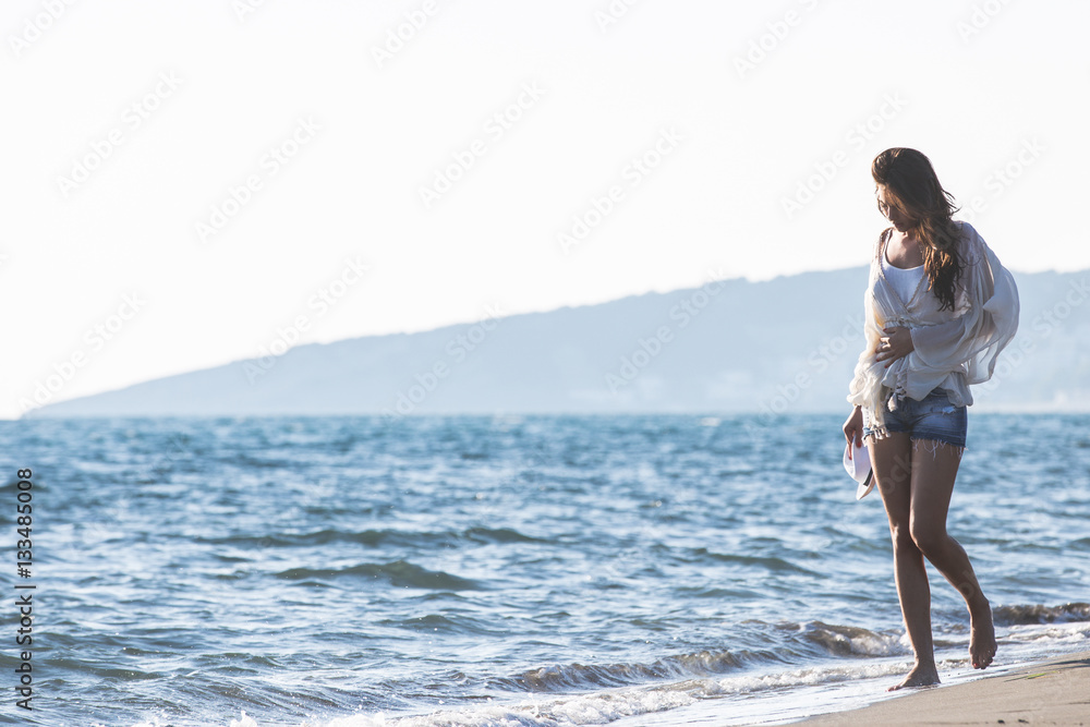 Young female enjoying sunny day on tropical beach