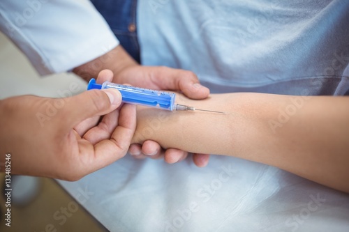 Doctor giving an injection to the patient